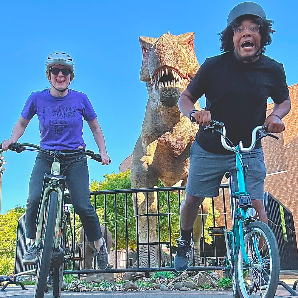 Two woman with a plastic dinosaur in the background